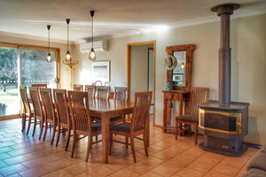 Large dining table and fire place in accommodation available to book for weekends at River Flats Estate